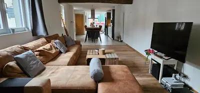 a living room with a couch and a flat screen tv at Comme chez Soi in Liège