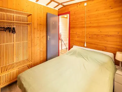 a bedroom with a bed in a wooden wall at Holiday Home in Lanklaar near Forest Trails in Lanklaar