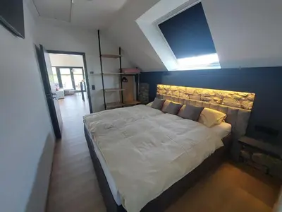 a bedroom with a large white bed with a skylight at L'Appart - New Appartement - Free Parking - Self Check-in - Terrasse in Eynatten