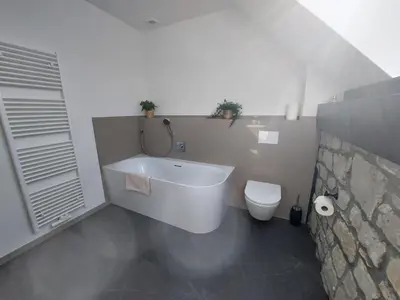 a bathroom with a white tub and a toilet at L'Appart - New Appartement - Free Parking - Self Check-in - Terrasse in Eynatten