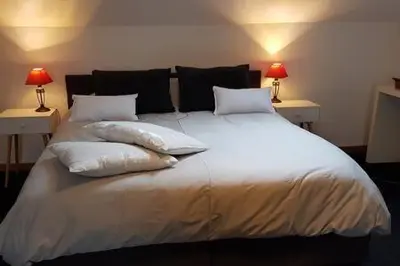 a large white bed with pillows and two lamps at Take a break in Voeren