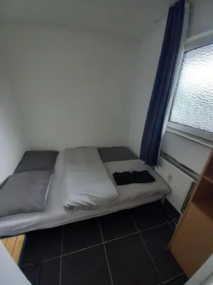 a small bed in a room with a window at Ap78 Nature Ardennes Economy class apartment in La Calamine