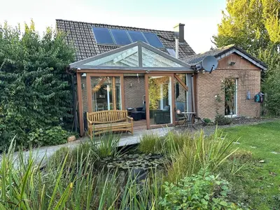 a house with a conservatory with a bench on a deck at Raelax in Raeren