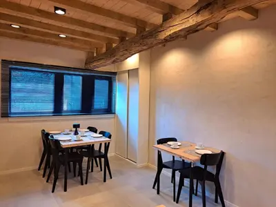 a dining room with tables and chairs and a window at Hoeve BôThé - B&B in Alken