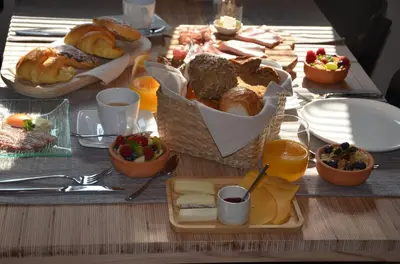 a table with a bunch of bread and other foods at Hoeve BôThé - B&B in Alken