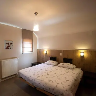 a bedroom with a large bed in a room at Alfonsinehoeve - we gaan zelf niet op vakantie, de vakantie komt naar ons in Heers