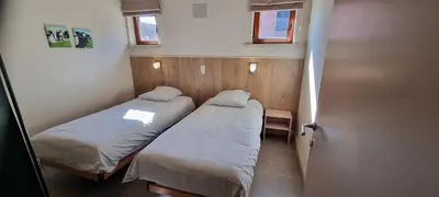 two beds in a small room with two windows at Alfonsinehoeve - we gaan zelf niet op vakantie, de vakantie komt naar ons in Heers