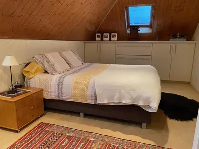 a bedroom with a bed and a kitchen with a window at Nachtegaal in Dilsen-Stokkem