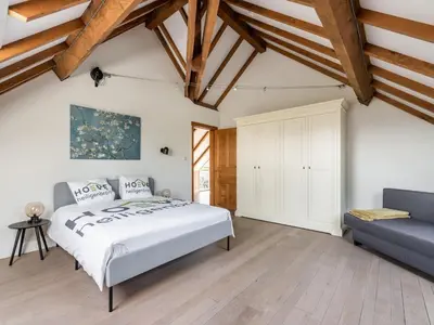 a bedroom with a bed and a couch at Farmhouse including studio with Garden in Alken