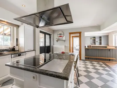 a kitchen with a large island with a counter top at Farmhouse including studio with Garden in Alken