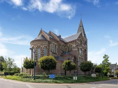a large brick church with a steeple on a street at Farmhouse including studio with Garden in Alken