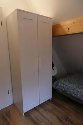 a white cabinet in a bedroom with a bed at De Onthaasting in Lanaken