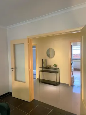 a room with a door and a table and a mirror at Comfortable stay in Tongeren in Tongeren