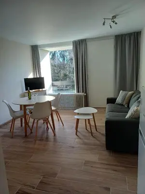 a living room with a table and a couch at Sunny and bright apartment Kelmis La Calamine Neu Moresnet in La Calamine