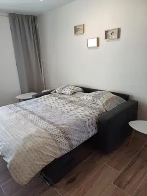 a bedroom with a bed and two tables at Sunny and bright apartment Kelmis La Calamine Neu Moresnet in La Calamine