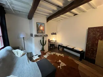 a living room with a bed and a table at La petite maison de l'impasse in Liège