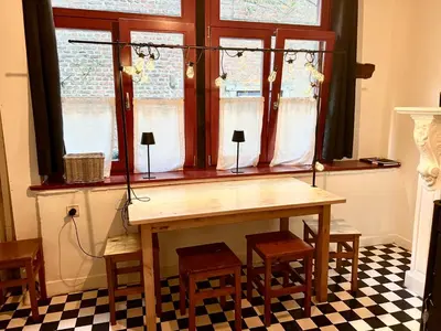 a table and chairs in a room with a window at La petite maison de l'impasse in Liège