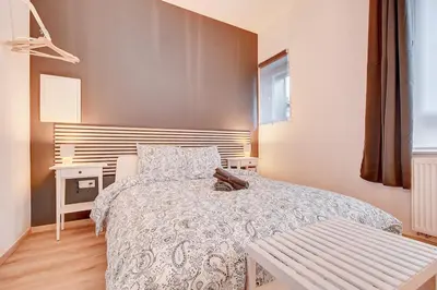a bedroom with a bed and a bench in it at Le cocon de la gare - centre in Liège