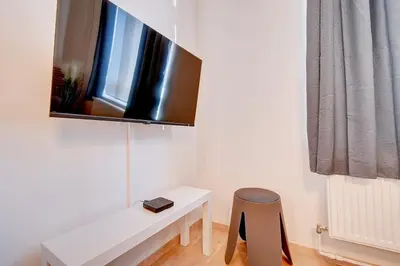 a small room with a white table and a stool at Le cocon de la gare - centre in Liège