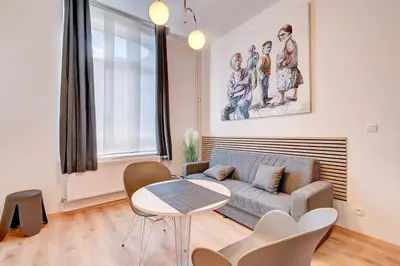 a living room with a couch and a table at Le cocon de la gare - centre in Liège