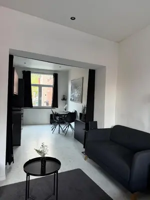 a living room with a couch and a table at Magnifique appartement moderne in Liège