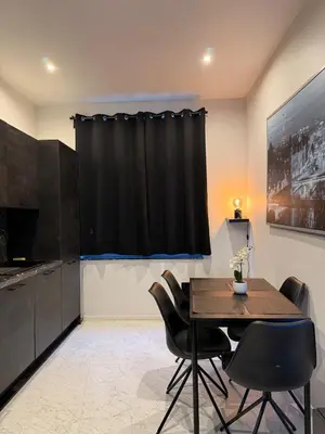 a dining room with a table and black curtains at Magnifique appartement moderne in Liège