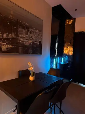 a dining room with a black table and chairs at Magnifique appartement moderne in Liège