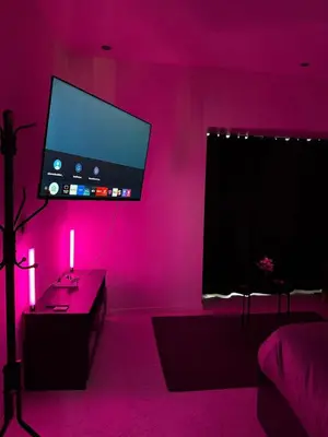 a pink room with a tv and a table with a candle at Magnifique appartement moderne in Liège