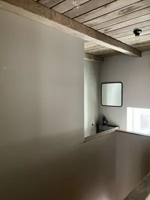 a room with a tv on a white wall at Huisje Emma in Tongeren