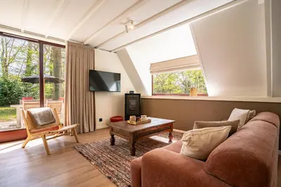 a living room with a couch and a table at Boshuisje Rekem - Ember in Lanaken