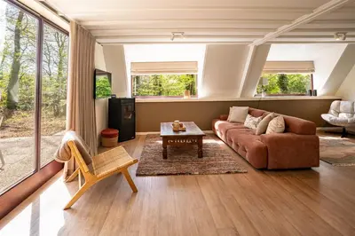 a living room with a couch and a table at Boshuisje Rekem - Ember in Lanaken
