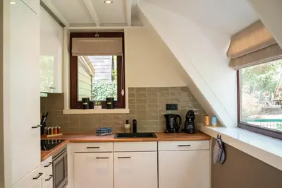 a kitchen with white cabinets and a sink at Boshuisje Rekem - Ember in Lanaken