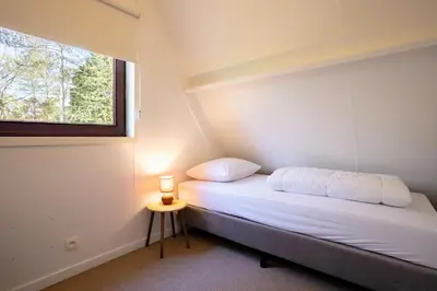 a small bed in a room with a window at Boshuisje Rekem - Ember in Lanaken