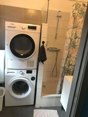 a washing machine in a bathroom with a shower at Appartement confortable proche centre et idéal pour ULiège Sart Tilman in Liège