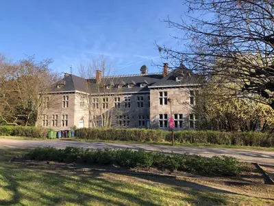 a large stone building on the side of a road at Appartement confortable proche centre et idéal pour ULiège Sart Tilman in Liège