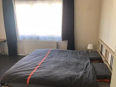 a bedroom with a large bed and a large window at Appartement confortable proche centre et idéal pour ULiège Sart Tilman in Liège