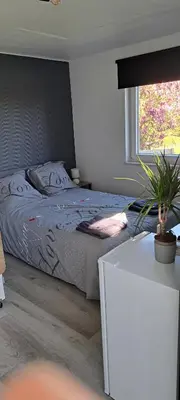 a bedroom with a bed and a large window at Au coin du hérisson in Olne