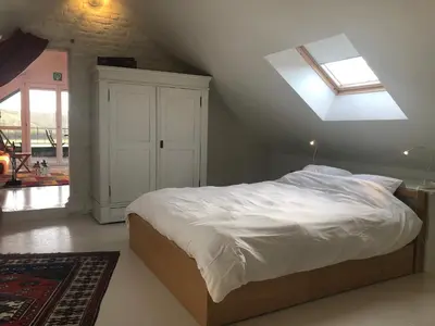 a bedroom with a large bed with a skylight at Land van Engelingen in Helshoven