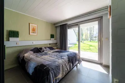 a bedroom with a bed and a large window at Acacia 8 Hengelhoef in Houthalen-Helchteren