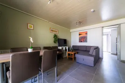 a living room with a long table and a couch at Acacia 8 Hengelhoef in Houthalen-Helchteren