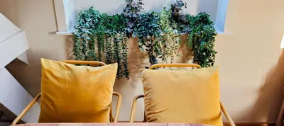a table with two yellow pillows and a plant at 't Herenhoes in Pelt