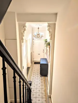 a hallway with a stairway with a suitcase at 't Herenhoes in Pelt