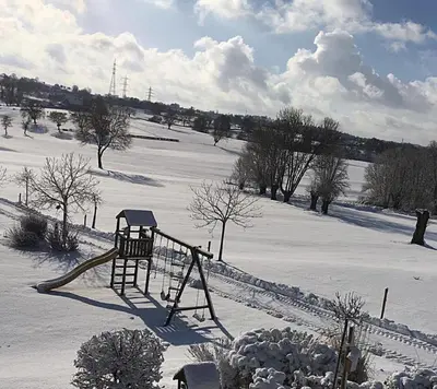 a playground in a snow covered field with trees at Country house Au Ballet des Hirondelles in Herve