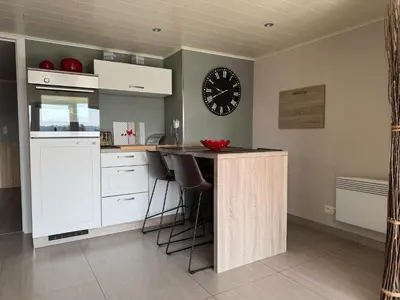 a kitchen with a counter and a clock on the wall at Country house Au Ballet des Hirondelles in Herve