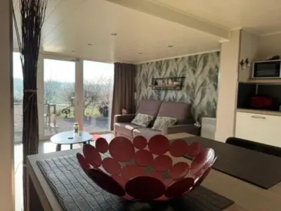 a living room with a couch and a red chair at Country house Au Ballet des Hirondelles in Herve