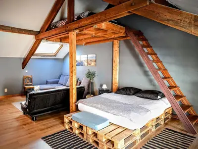 a bedroom with a large bed and a loft at La Cachette d 'Amercoeur in Liège