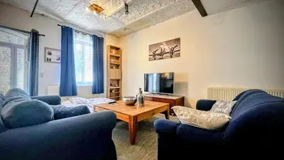 a living room with two blue couches and a table at Le Rez d'Amercoeur in Liège