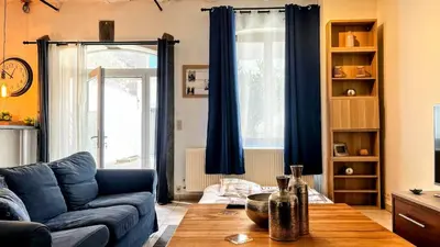 a living room with a blue couch and a wooden table at Le Rez d'Amercoeur in Liège