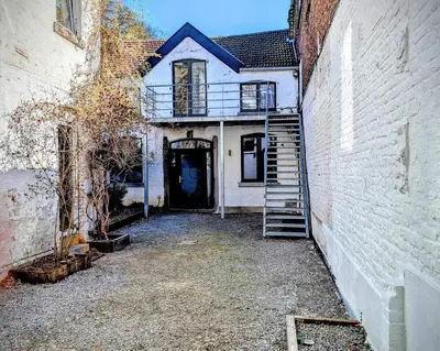 an old house with a staircase leading to a door at Le Rez d'Amercoeur in Liège