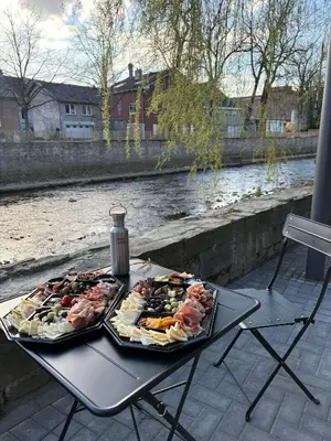 two trays of food on a table next to a river at Weserwasser in Eupen